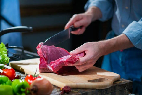 Skilled hands slicing beef with precision, preparing the perfect cuts for delicious beef jerky.