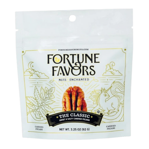 Bag of Fortune Favors 'The Classic' sweet & salty candied pecans, featuring whimsical gold illustrations of a unicorn, plants, and stars on a white background. The packaging includes a central image of a pecan and the tagline 'Nuts Enchanted'.
