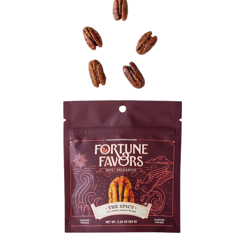 Bag of Fortune Favors 'The Spicy' chili-spiked candied pecans with five pecans floating above. The rich red packaging features mystical artwork and the tagline 'Nuts Enchanted' below a golden pecan.