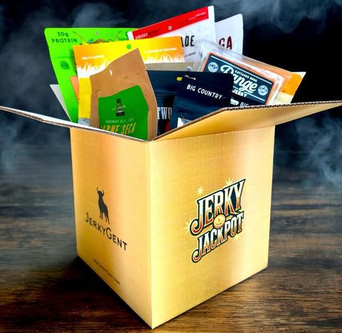 Box of assorted jerky packages labeled "Jerky Jackpot" on a wooden table with a smoky background.