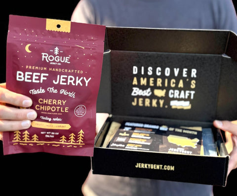 Person holding a package of Rogue Beef Jerky and an open box from Jerky Bent.