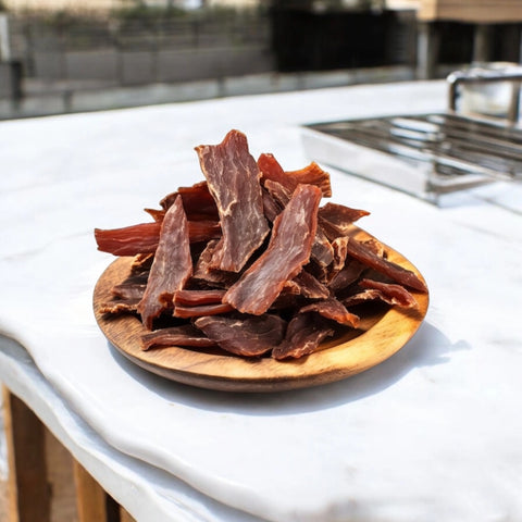kangaroo jerky slices on wooden plate outdoors