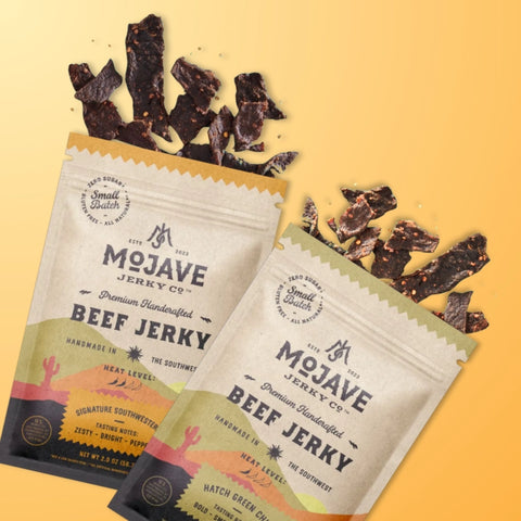 An image of both Mojave Jerky Co. flavors with jerky bursting out of each bag