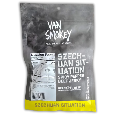 Back of a Van Smokey "Szechuan Situation" Spicy Pepper Beef Jerky bag. The packaging features a smoky black and gray design with white bold text. It includes branding ("Van Smokey – Real Smokey. No Jokey."), product name, nutritional facts, ingredients, and highlights such as "Made with Grass-Fed Beef" and "No Added Antibiotics or Hormones." The bottom edge of the bag has a bright yellow band with the flavor name repeated.