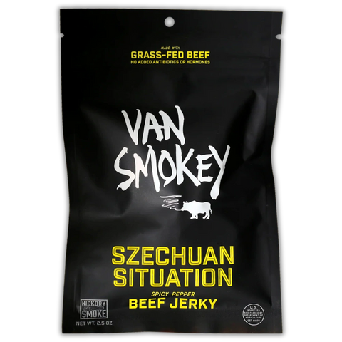 A matte black pouch of Van Smokey beef jerky. The packaging features bold, white text reading "VAN SMOKEY" with a silhouette of a smoking pig underneath. In bright yellow lettering, it says "SZECHUAN SITUATION" followed by "Spicy Pepper Beef Jerky." The top highlights that the jerky is made with grass-fed beef and contains no added antibiotics or hormones. A small label at the bottom corner notes “Hickory Smoke” and the weight of 2.5 oz.