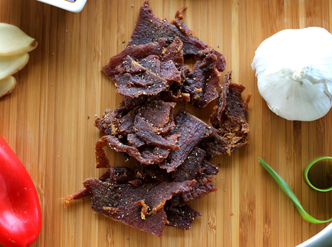 Savory Exotic Jerky on a Table with Garlic and Pepper - Discover Bold and Unique Flavors
