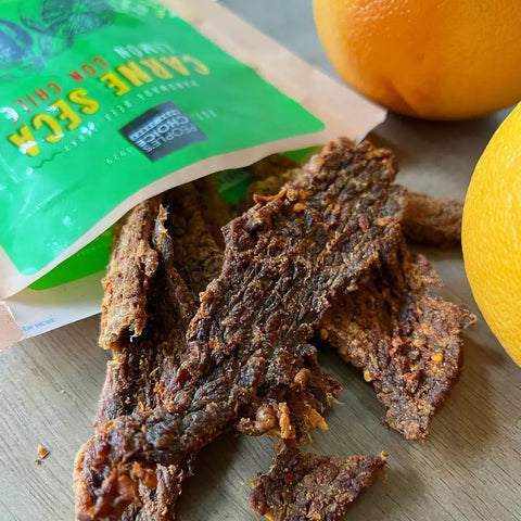 Sugar-free, keto-friendly, super healthy beef jerky spilling out of the bag onto a table.