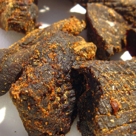 Riley's Jerky showcasing their hearty seasoned beef jerky pieces with a textured surface. The jerky appears rich, thick, and full of bold flavors.