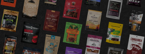 Flat lay of assorted beef jerky brands on black table, showcasing 400+ premium craft flavors, including spicy, smoky, and small-batch varieties.