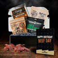Assorted beef jerky packages in a beef jerky gift box with a birthday greeting card on a dark background