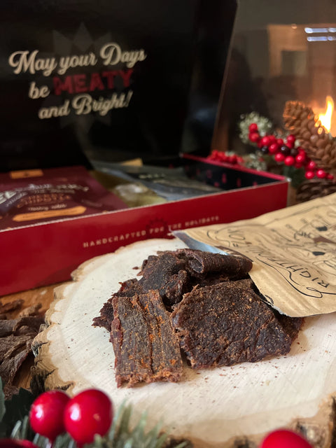 A beef jerky gift box with handcrafted jerky spilling out showcasing the great texture of the jerky.