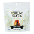 Bag of Fortune Favors 'The Classic' sweet & salty candied pecans, featuring whimsical gold illustrations of a unicorn, plants, and stars on a white background. The packaging includes a central image of a pecan and the tagline 'Nuts Enchanted'.