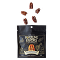 Bag of Fortune Favors 'The Everything' sweet & savory candied pecans with five seasoned pecans floating above. The dark packaging features celestial gold illustrations and a central image of a pecan under the tagline 'Nuts Enchanted.'