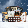 JerkyGent Holiday Edition plaid gift box displayed in the snow, filled with assorted small-batch beef jerky bags and Fortune Favors pecans against a snowy winter background.