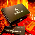 The JerkyGent Inferno Box surrounded by assorted spicy craft jerky packs, set against a backdrop of fire.
