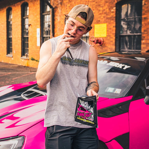 Open Road Jerky Original Burn Out Beef Jerky being eaten in front of pink muscle car