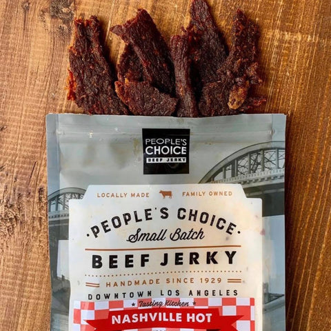 A close-up photo of Nashville Hot beef jerky by People's Choice, that showcases the red hue and delectable texture of the jerky itself