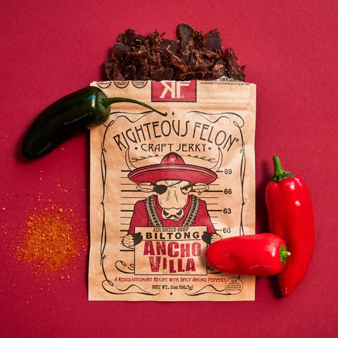 Ancho Villa Biltong Spilling Out with Red Background and Peppers