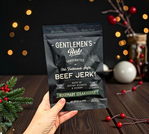 Hand holding a package of Gentlemen's Best Beef Jerky with festive background