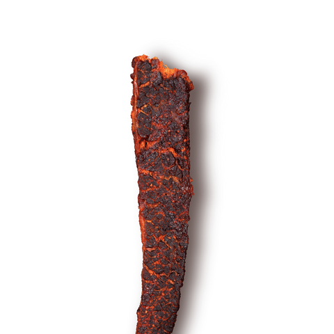 Close up of peoples choice beef jerky gochujang flavor showing the texture and deep red color.