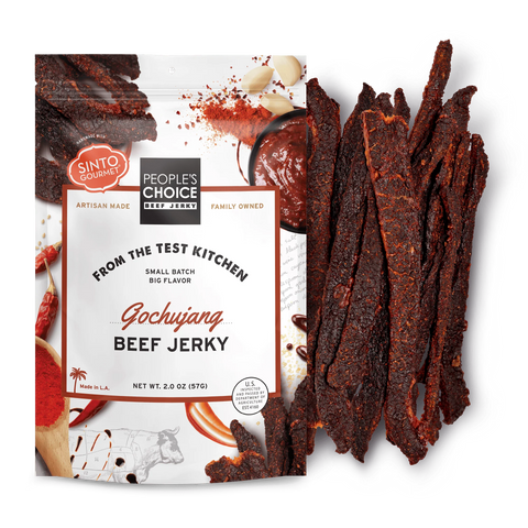 A bag of peoples choice beef jerky gochujang flavor with a pile of beef jerky next to it.
