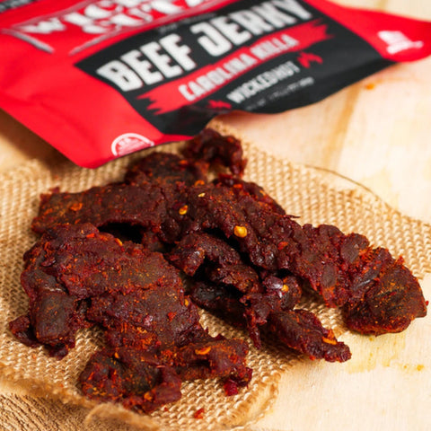 a close-up photo of Carolina Killa beef jerky by Wicked Cutz, which shows the intense red tint and Carolina Reaper pepper seeds infused into the beef